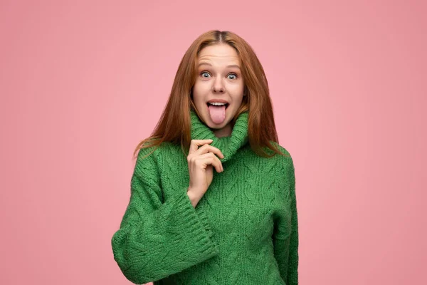 초록색 스웨터를 내보이면서 배경에 우스운 얼굴을 — 스톡 사진