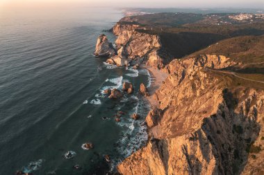 Portekiz 'de gün batımında fırtınalı denizin yakınında bulunan inanılmaz uçurumların ve Ursa Sahili' nin yukarıdan görünüşü.