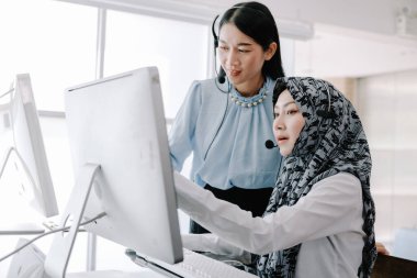 Sekreter operatörü danışman yardımı için kulaklık ve mikrofon takar, çağrı merkezi personeli gülümseyen ve mutlu bir şekilde müşterilere tavsiye ve yardım eder