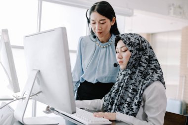 Sekreter operatörü danışman yardımı için kulaklık ve mikrofon takar, çağrı merkezi personeli gülümseyen ve mutlu bir şekilde müşterilere tavsiye ve yardım eder