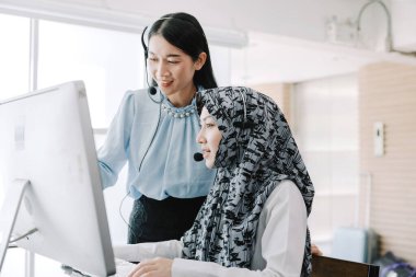 Sekreter operatörü danışman yardımı için kulaklık ve mikrofon takar, çağrı merkezi personeli gülümseyen ve mutlu bir şekilde müşterilere tavsiye ve yardım eder