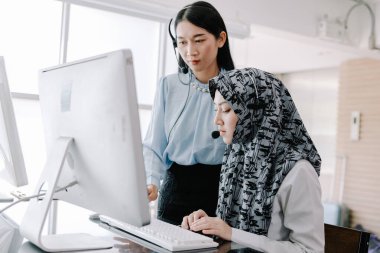 Sekreter operatörü danışman yardımı için kulaklık ve mikrofon takar, çağrı merkezi personeli gülümseyen ve mutlu bir şekilde müşterilere tavsiye ve yardım eder