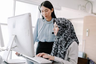 Sekreter operatörü danışman yardımı için kulaklık ve mikrofon takar, çağrı merkezi personeli gülümseyen ve mutlu bir şekilde müşterilere tavsiye ve yardım eder