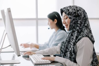 Sekreter operatörü danışman yardımı için kulaklık ve mikrofon takar, çağrı merkezi personeli gülümseyen ve mutlu bir şekilde müşterilere tavsiye ve yardım eder