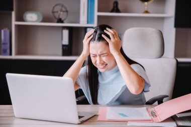 Patron masasında oturmuş şirketin sorunlarından kaynaklanan stresi gösteriyor..