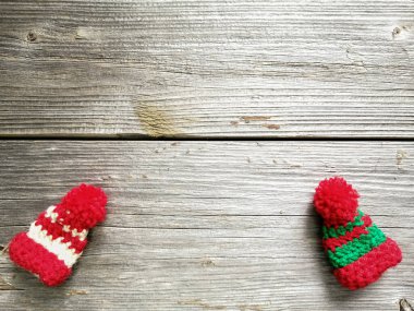 Tahta tahtaların üzerinde el yapımı güzel şapkalar. Kış motifleri.