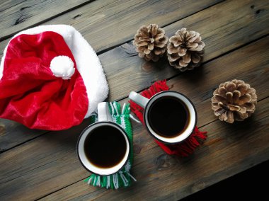 Tahta masanın üzerinde Noel Baba, koni ve iki fincan sıcak americano var. Şen şakrak. Noel ve Yeni Yıl.