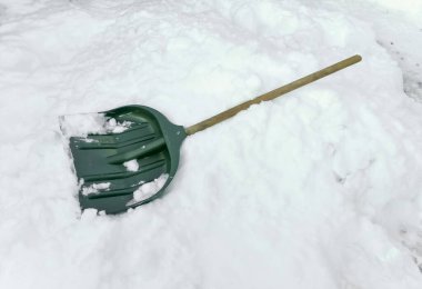 Kar küreği yalan söylüyor. Kışın karları temizlemek için yeşil kürek. Kışın yolların temizlenmesi. Çok kar var. Kar temizleme için yeşil kürek.