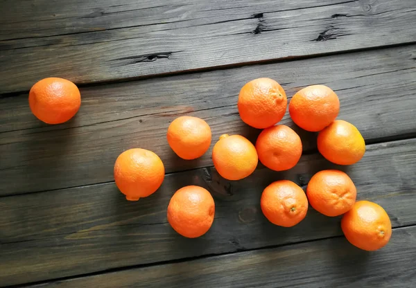 在一张木制桌子上 有许多克莱门汀的亮晶晶的橘子 整个橘子在桌子上 冬天的水果是橘子 木板上的橘子橘子橘子 — 图库照片