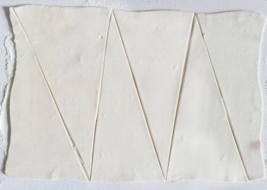 Üçgenlere böl hamuru ayçöreğine. Kruvasan için puf böreği. Hamuru güzelce kruvasana çevir..