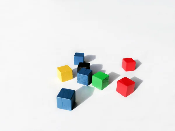 Färgade, trä kuber är utspridda över en vit bakgrund. Barnkuber. trä kuber för spelet. — Stockfoto