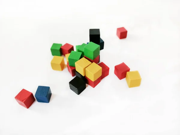 Hay muchos cubos de colores sobre un fondo blanco. Cubos para niños para jugar de madera de diferentes colores. —  Fotos de Stock