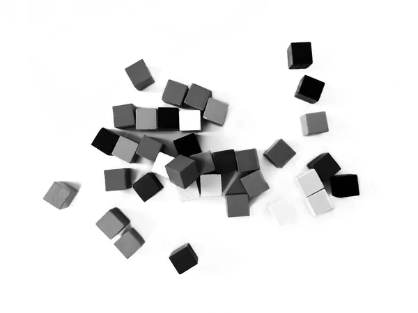 Hay muchos cubos de colores sobre un fondo blanco. Cubos de niños para jugar desde madera. Foto en blanco y negro —  Fotos de Stock