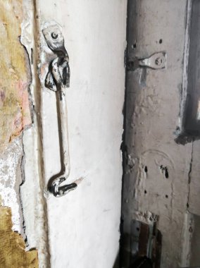 Kapıya kanca takın. Kapıda basit bir kilit var. Kırsal tarzda, kapıya kanca şeklinde basit bir kilit. Eski kanca sallanıyor..