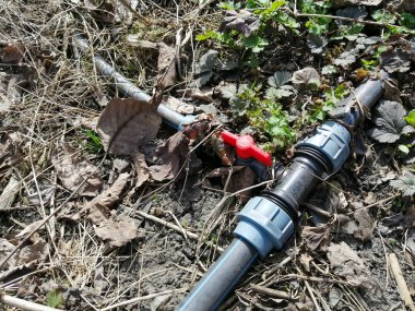 Bahçe hortumuna su sağlamak için girdap. Su kaynağı için musluğu olan eski bahçe hortumu. Hortumdaki su tıkanmış. Su kaynağı yok. Eski valf.