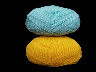 Siyah arka planda iki yün ip bobini. Gelot mavisi. Sıcak iplikleri olan Ukrayna bayrağı. Siyah arka planda sıcak renkler. Renkli başlıklar ve siyah arkaplan karşıtlığı.