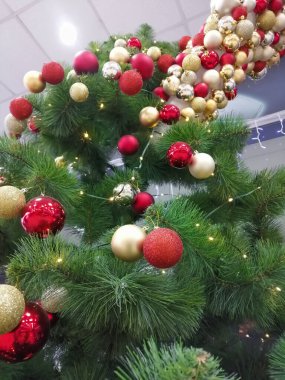 Original decoration of the Christmas tree with balls. Red and yellow balls for decorating the Christmas tree for the New Year and Christmas.
