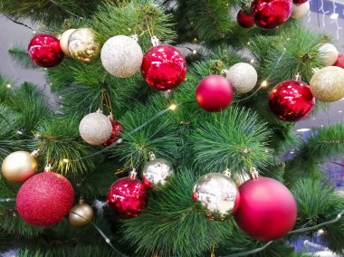 Noel ağacında bir sürü sarı ve kırmızı toplar var. Dekorasyon bolluğu... .