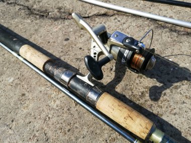 Beton zeminde bobinli olta kamışı. Oltayla olta. Oltada iyi makaralar var. Dönüyor. Her şey ribalka için..