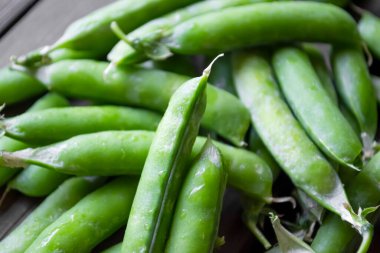 Kabuklu bezelyeler. Yeşil bezelye dizeleri bir yığın içinde yatıyor. Bir sürü kapsül. Bezelyenin yeşil rengi.. Kullanışlı bobble ekinleri.