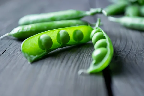Green pea beans in a pod on a wooden table. Beans in a pod. green peas with open pod.