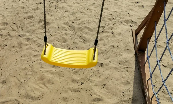 Gele Schommel Kinderschommel Met Gele Zitting Speeltuin Het Zand Ligt — Stockfoto