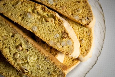 Biscotti with peanuts on a plate. Bread with nuts on a glass plate. On the plate are several pieces of fresh biscotti.