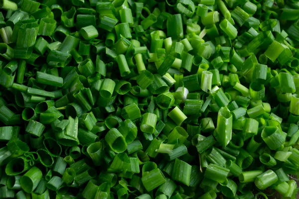 Chopped green onions. Chopped and green onions. Preparations for the winter - green onions. Chopped feather onion. Food background photo of green onions.