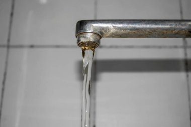 Water flows from the tap. Bottom-up view. The photo below is a view of the faucet in the bathroom from which water flows. Beautiful flow of water from the tap.