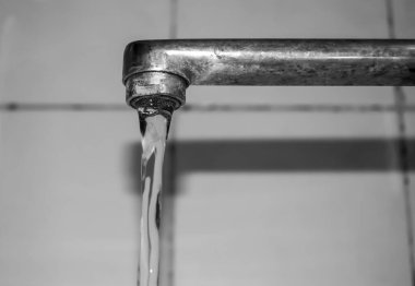 Water flows from the tap. Bottom-up view. The photo below is a view of the faucet in the bathroom from which water flows. Beautiful flow of water from the tap.