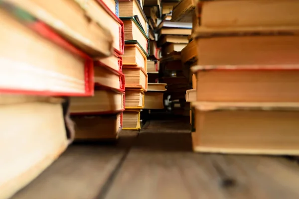 Rows of books. Stacks of books stand in rows on the table. Book photo from bottom to top. Macro photography of stacks of books on the table. Lots of books on the wooden floor.