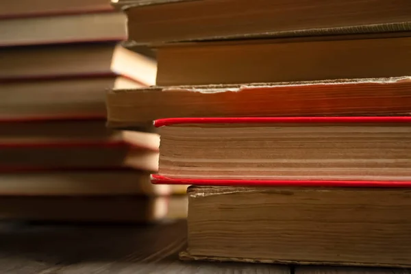 Stacks are taken. From the stack of books, one stands out, in a red cover. A book with a red cover in a stack of gray books. Lots of books. Photo photo of books.