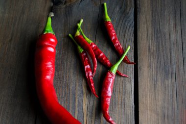 Lots of different chili peppers on the table. Red hot peppers. Red hot pepper, different types. two kinds of hot peppers on a wooden table.