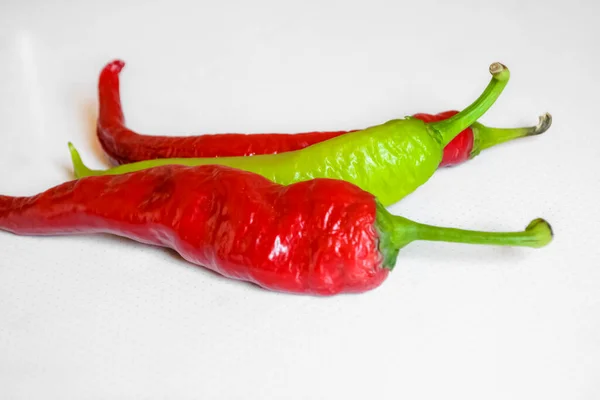 Een Witte Tafel Liggen Drie Pepers Twee Rode Een Groene — Stockfoto