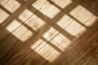 Yerde pencereden gelen bir gölge ve ışık var. Ahşap parkede kafesteki pencereden gelen bir gölge var. Pencereden süzülen gölgeler, yerde lahanalar....