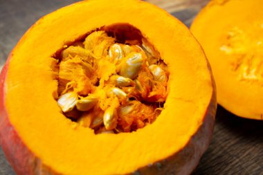 Balkabağının içindeki tohumlar. Çekirdekle balkabağını kes. Tahtadaki çekirdekli balkabağı. Hokkaido çeşitliliği.