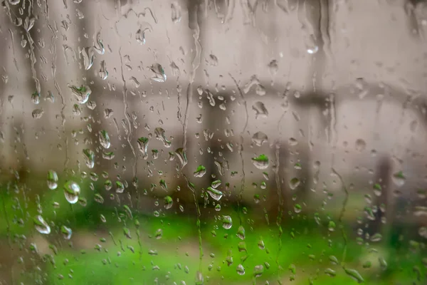 Cama yağmur damlaları damlıyor. Pencere yağmur damlalarının içinde. Camdan aşağı su akıyor. Pencerenin dışında yağmur yağar.