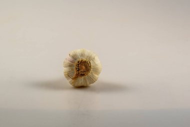 Sarımsak ampulünün alt kısmını beyaz bir arka plana yakın plan.