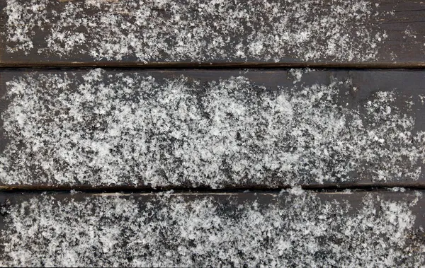 Taze karla kaplı boyanmış kahverengi tahtaların ahşap yüzeyi.