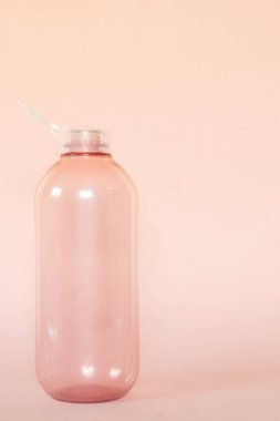 Dikey yakın plan boş plastik şişe, geri dönüşüm konsepti pembe arkaplan ve boşluk kopyala