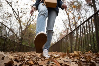 Formda kalmak, odaklanmak ve boşluğu kopyalamak için parkta yürüyen tanınmayan kadının düşük açısı