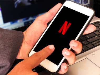 Mobil merkezde Netflix logosu olan Smartphone konsepti. Modern eğlence arkaplanı