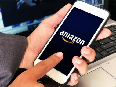 New York, Birleşmiş Devletler, 2021. Amazon Mobil uygulaması ekranda elinde cep telefonu olan bir adam var. Editör ekommerce kavramı
