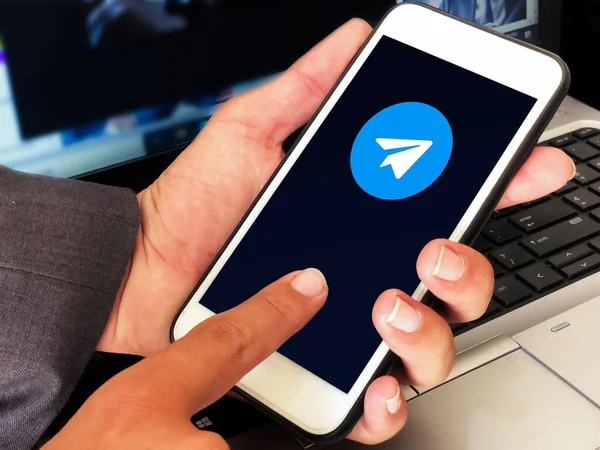 Genç Adam 'ın elindeki Mobil Ekran içindeki Editoryal Telgraf Simgesi. Modern sosyal medya trend arkaplanı
