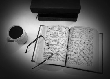 Beyaz Masa üzerinde kahve ve gözlük olan siyah ve beyaz kitap okuma konsepti. Modern ve Eski Eğitim kavramı