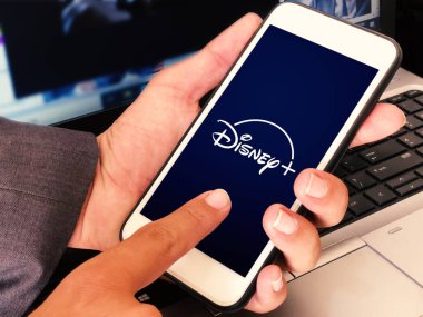Mobile 'de Disney Uygulamasını Ekranda Dokunarak Kullanan Adam. Smartphone uygulama kavramı editoryal arkaplan.