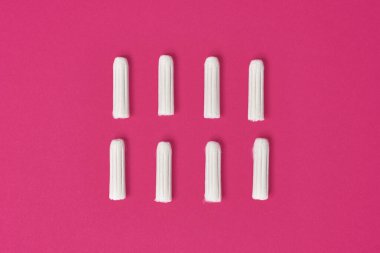 Pembe arka planda adet görmek için hijyenik kadın tamponları.