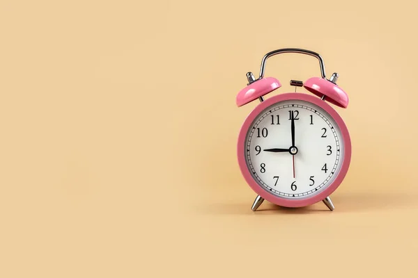 Bej arka planda pembe alarm saati. Saat 9: 00 'da. Uzayı kopyala Fotoğraf.
