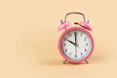 Bej arka planda pembe alarm saati. Zaman kavramı. Saat 10 yönünde. Uzayı kopyala Fotoğraf.