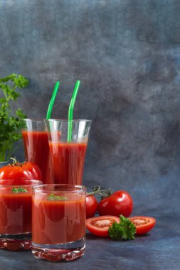 Bardakta domates suyu, domates ve arkaplanda maydanoz. Uzayı kopyala Fotoğraf.